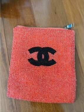 Beaded small pouch. Orange beads with black bead logo.